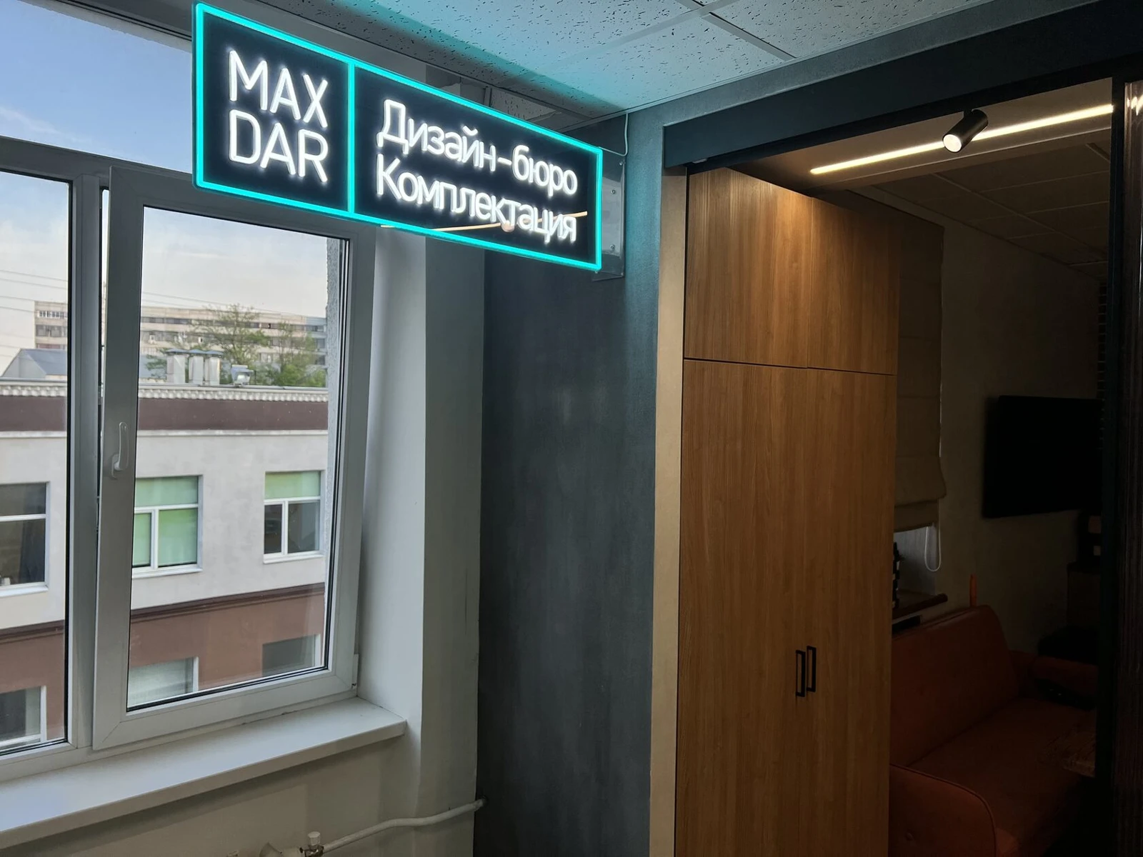 Прямоугольная зелёно-белая неоновая вывеска MAX DAR над входом