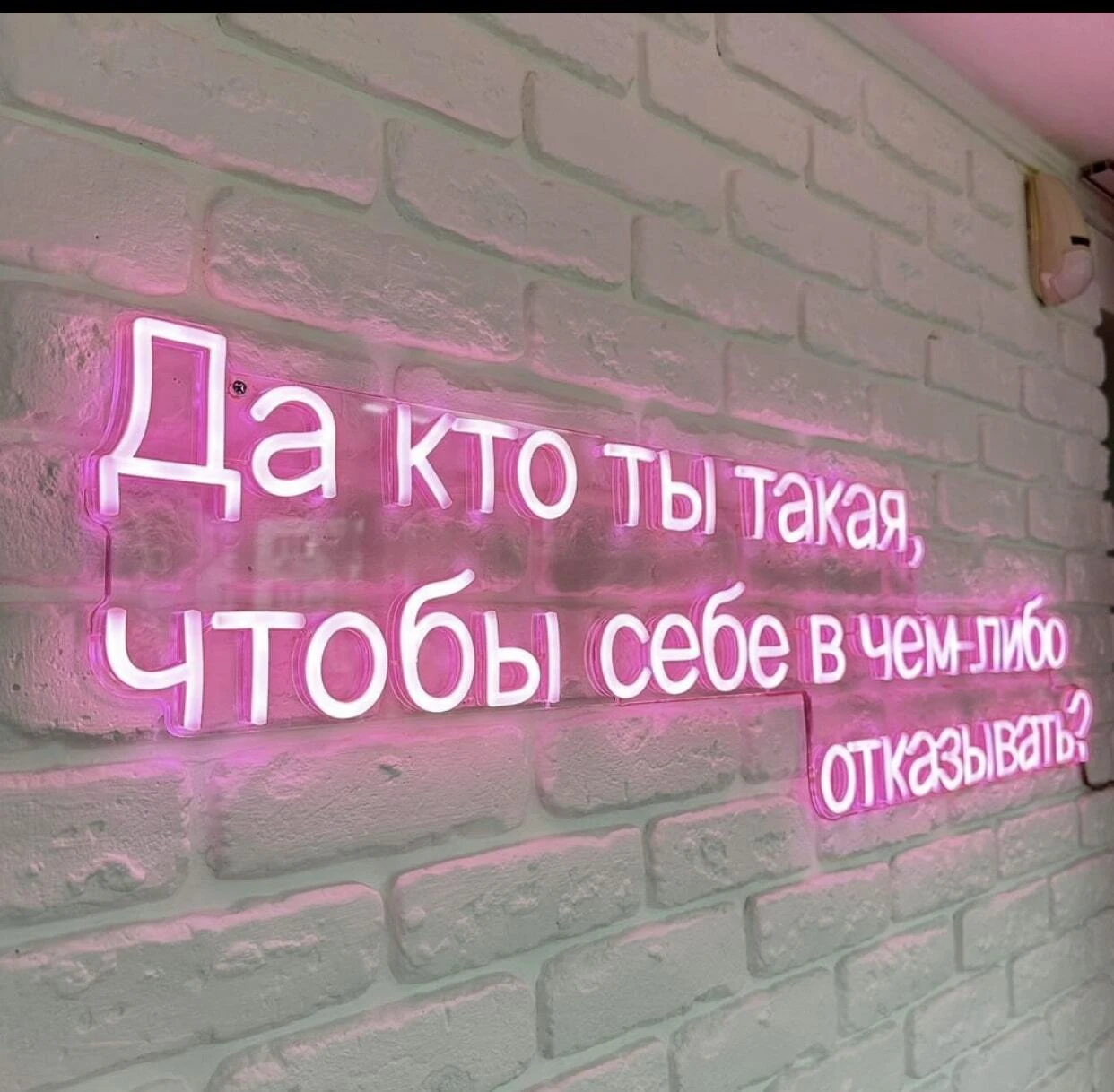 Розовая неоновая фраза на белой кирпичной стене